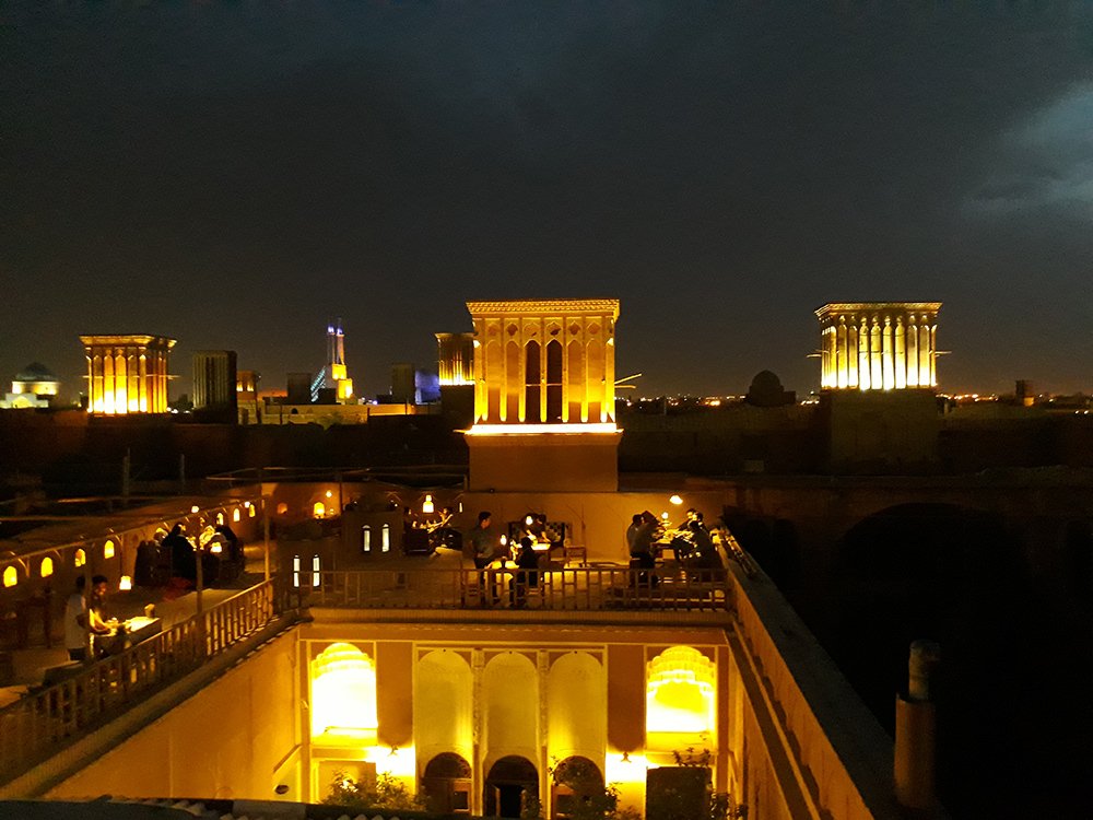Yazd at night with rooftop cafes offering views of the illuminated historic city and adobe buildings